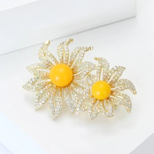 Élégante broche double tournesol avec pierres d'ambre jaune et pavé de cristaux sur blanc