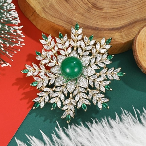 Sparkling snowflake brooch with green cabochon and marquise zircon in festive style