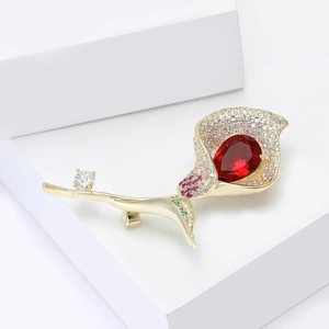 Vue détaillée d'une broche calla avec gemme rouge goutte et cristaux roses pavés