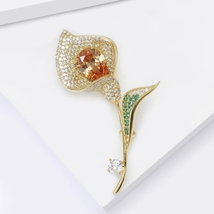 Détail d'une élégante broche tulipe en or avec micro-pavage de zircons étincelants