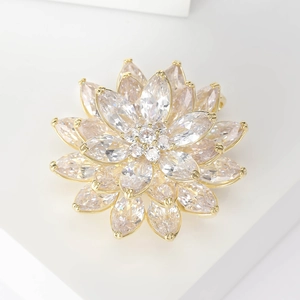 Detail of multi-layer sparkling lotus brooch with marquise-cut crystals in gold finish
