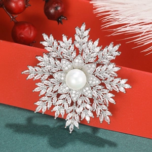 Macro shot of snowflake brooch with white pearl and sparkling zircon on silver base