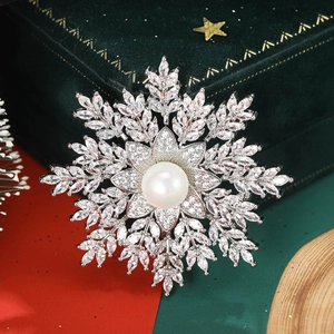 Macro shot of silver snowflake brooch with white pearl and sparkling zircon stones