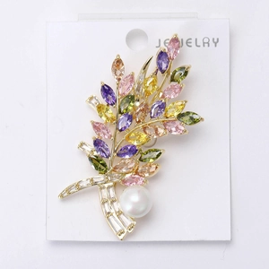 Detaillierte Nahaufnahme einer bunten Kristall-Blumenbrosche mit weißer Perle und Goldbasis