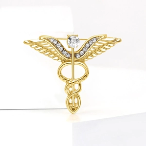 Detail of golden Caduceus brooch with sparkling rhinestone wings and polished metal finish