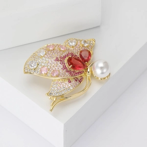 Spilla a farfalla elegante con zirconi rosa e perla bianca su una base dorata