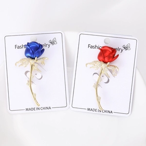 Detail van matte emaille rozenbroches met micro-zirkonia in rood en blauw