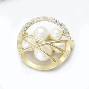 Detailed macro view of vintage round gold brooch with pearls and micro-pave cubic zirconia