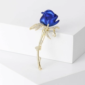 Macro detail van de blauwe emaille roos broche met gouden steel en zirkonia steentjes