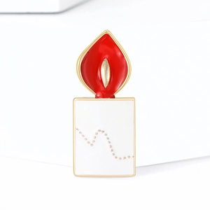 Creative red candle enamel brooch with golden metal edges on a minimalist white background