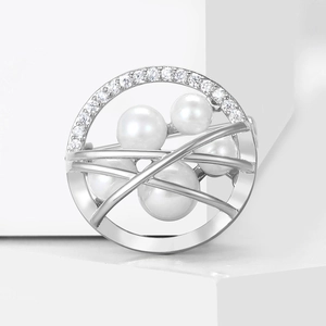 Elegant silver brooch featuring zircons and five white pearls on a geometric white stand