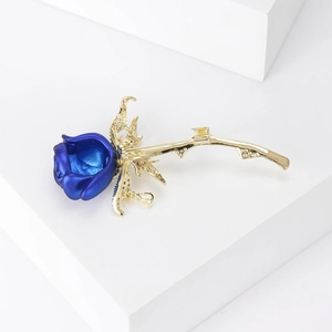 Detail van de blauwe emaille rozenbroche met gouden steel en fonkelende zirkonia's