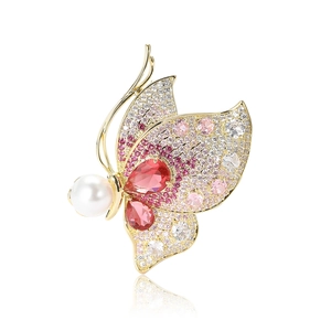 Elegante spilla a farfalla con cristalli rosa e una grande perla su cornice dorata