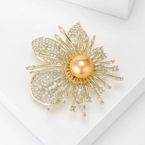 Broche orchidée en or avec une grande perle dorée et des zircons sur un socle blanc épuré