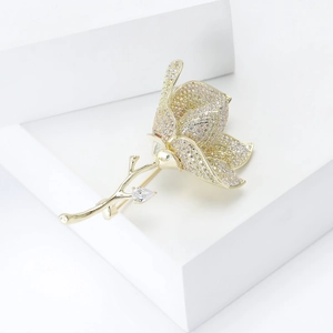 Macro detail of tulip brooch with pavé champagne cubic zirconia on white stone