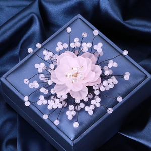 Detail of handmade pink crystal flower brooch with pearl beads on blue silk