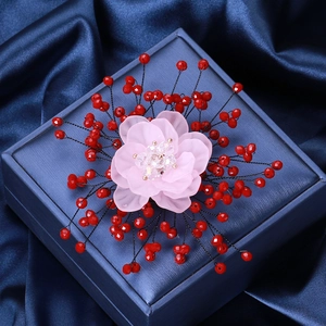 Pink crystal flower brooch with pearls and red beads on a blue velvet jewelry gift box