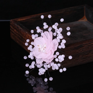 Detail of pink tulle flower brooch with crystal center and beaded wires on wood box
