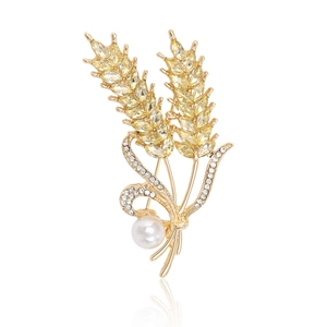 Détail de la broche épi de blé dorée avec cristaux ambrés et une grande perle blanche