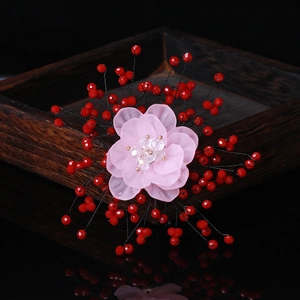 Detail of handmade crystal petal brooch with pearls and pink frosted petals on wooden tray