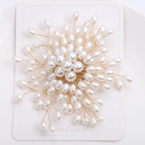 Dettaglio macro di spilla a fiore con perle intrecciate a mano e filo dorato su cartoncino