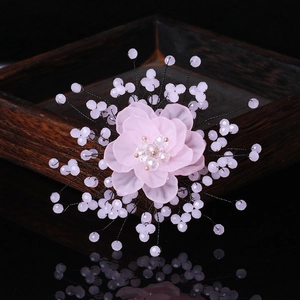 Pink crystal flower brooch with handmade pearl beads on a black reflective background