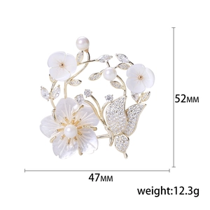 Broche fleur en nacre et papillon avec perles sur monture dorée raffinée