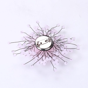 Detailed back view of handmade beaded flower brooch with silver safety pin fastener