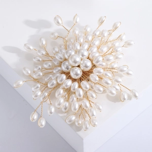Dettaglio ravvicinato della spilla di perle fatta a mano con intreccio dorato e design a fiori