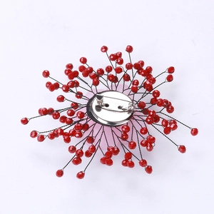 Macro view of the back of a red crystal flower brooch with handmade wire weaving details
