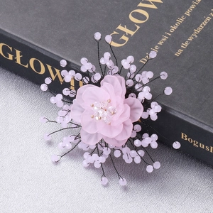 Close-up of pink crystal flower brooch with handmade beads and pearls decoration