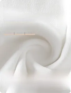 Gros plan sur le tissu doux en coton peigné blanc pour un gilet de bébé
