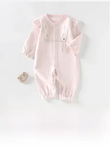 Pink cotton baby romper with lace details, ruffles, and safe snap buttons for girls