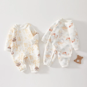 Flat lay of newborn quilted thermal rompers with traditional Chinese lion and dragon patterns