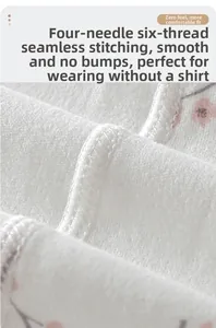 Détail du vêtement bébé en coton avec imprimé cerise et couture plate à quatre aiguilles