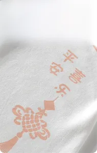 Détail d'un pyjama bébé en coton de classe A avec imprimés orange sur tissu blanc