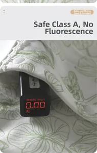 Close-up of baby bodysuit showing zero fluorescent agent test result on a digital monitor