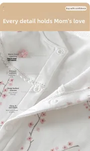 Détail d'un barboteuse pour bébé avec imprimé fleurs de prunier et col en dentelle