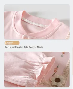 Detail of pink cotton baby bodysuit featuring U-neck collar and ruffled cuffs with lace decor