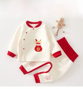 Detailed macro view of quilted cotton baby pajamas with festive red Chinese knot buttons