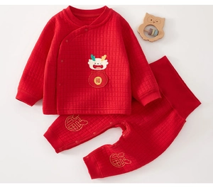 Detail of red quilted baby loungewear set with dragon embroidery and festive Fu patterns