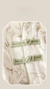 Detailed macro view of Chinese pankou buttons and bamboo leaf prints on baby romper