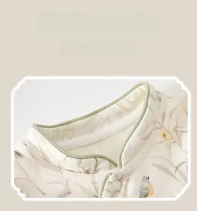 Detail of baby romper featuring a contrast Chinese mandarin collar and floral bird print