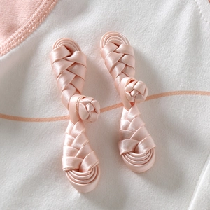 Boutons chinois roses en soie sur pyjama rayé pour bébé avec design traditionnel