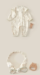 Detailed view of floral cotton infant romper with matching headband and botanical prints