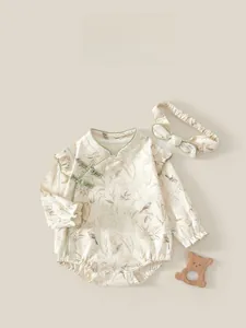 Detail of baby cotton bodysuit featuring vintage floral print and traditional frog buttons