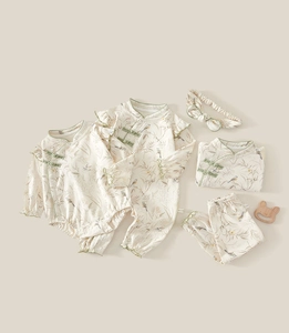 Detail of newborn baby five-piece set with floral print and traditional buttons