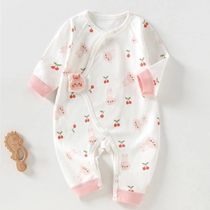 Détail d'un barboteuse bébé avec motif lapin et cerise et boutons-pression latéraux
