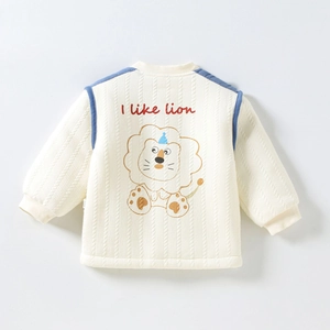 Détail de la veste matelassée pour bébé avec motif lion brodé et bordure bleue d'épaule