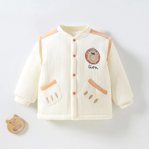 Détail de veste matelassée bébé avec broderie lion et texture tricotée épaisse
